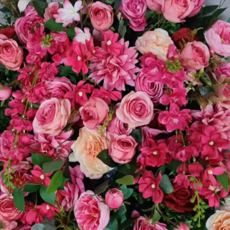 Edith A vibrant arrangement of pink and red roses with assorted flowers and green foliage.